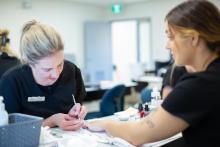 A student practices nail work on another student in the aesthetics and spa therapy classroom at VIU.