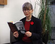 Katharina wears a poppy and holds a copy of her translation of All Quiet on the Western Front