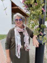 Mary Clare stands next to a lamppost with flowers trailing down it