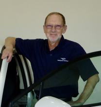 Les Dickason wears a Nanaimo Museum shirt and leans on a car